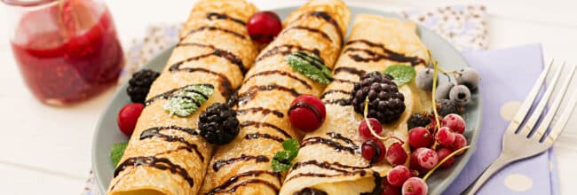 Pancakes with chocolate, jam and berries. Tasty breakfast.