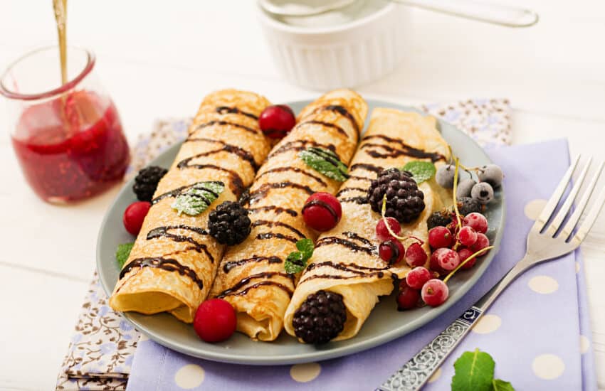 Pancakes with chocolate, jam and berries. Tasty breakfast.